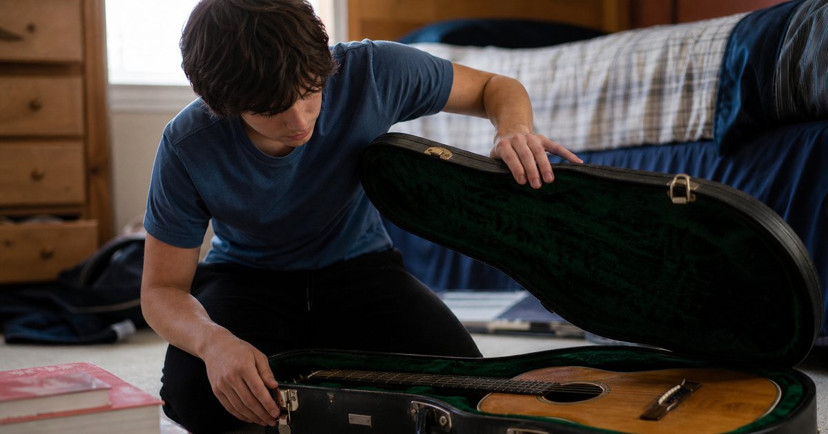 A teenage boy opening a dusty guitar case on his bedroom floor, guitar inside, sunlight from the window, a stack of school textbooks pushed to the side